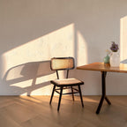 Homecrest mid-century modern charcoal teak wood and rattan wicker dining chair with a light upholstered seat cushion.