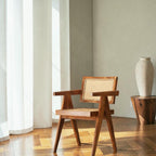 Homecrest Cavendish accent chair in natural teak wood with a woven rattan cane seat and backrest in a sunlit room.