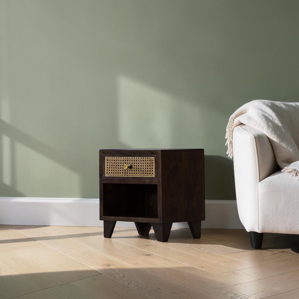 Homecrest Chalford bedside table in dark hardwood with a cane rattan drawer front and brass knob in a living room.