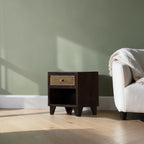 Homecrest Chalford bedside table in dark hardwood with a cane rattan drawer front and brass knob in a living room.