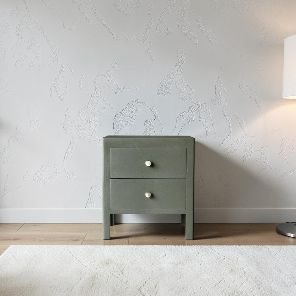 Homecrest Cranham bedside table in olive green hardwood with two drawers and round white knobs against a textured wall.