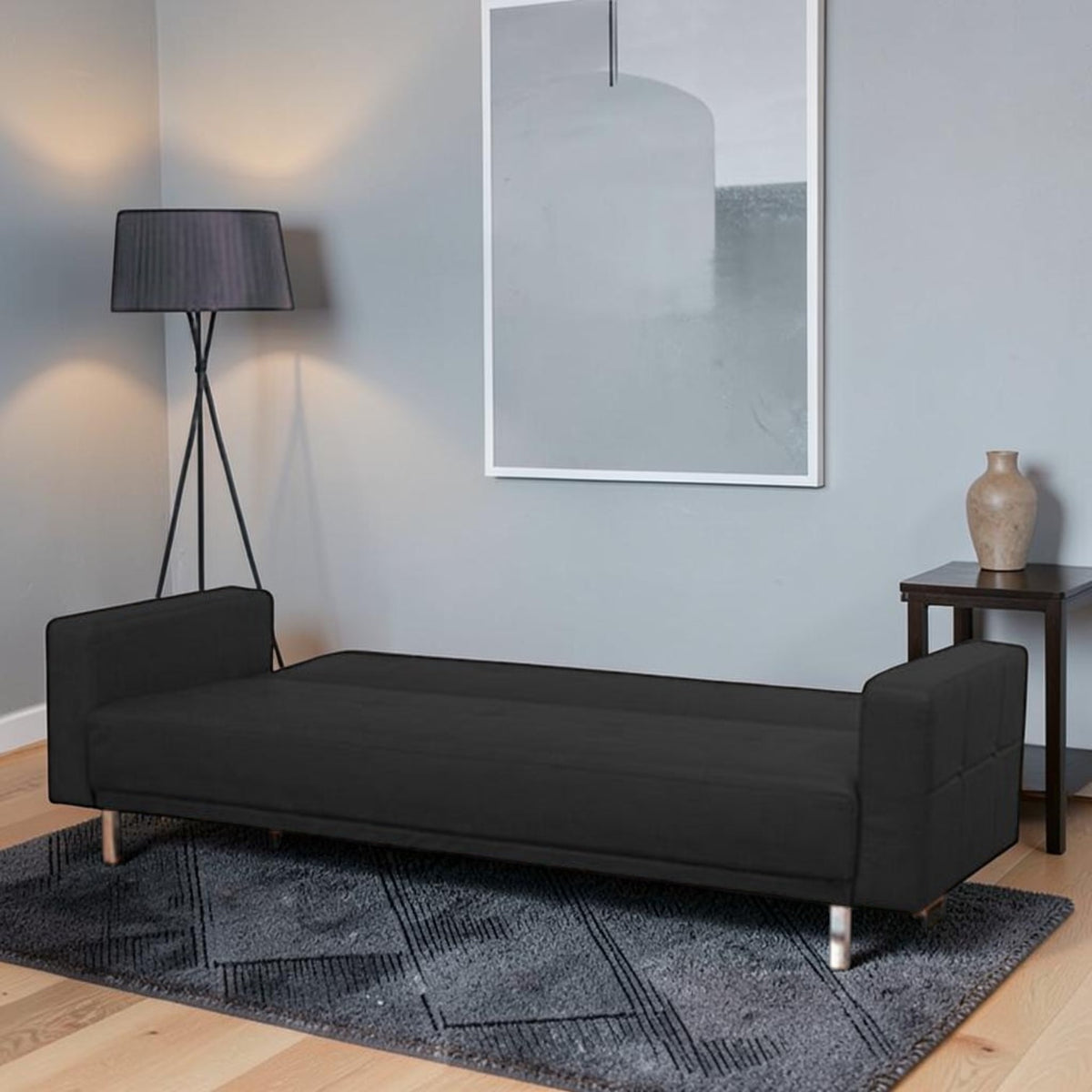 Homecrest Corbett black leatherette sofa cum bed in a modern living room setting with a floor lamp and side table.