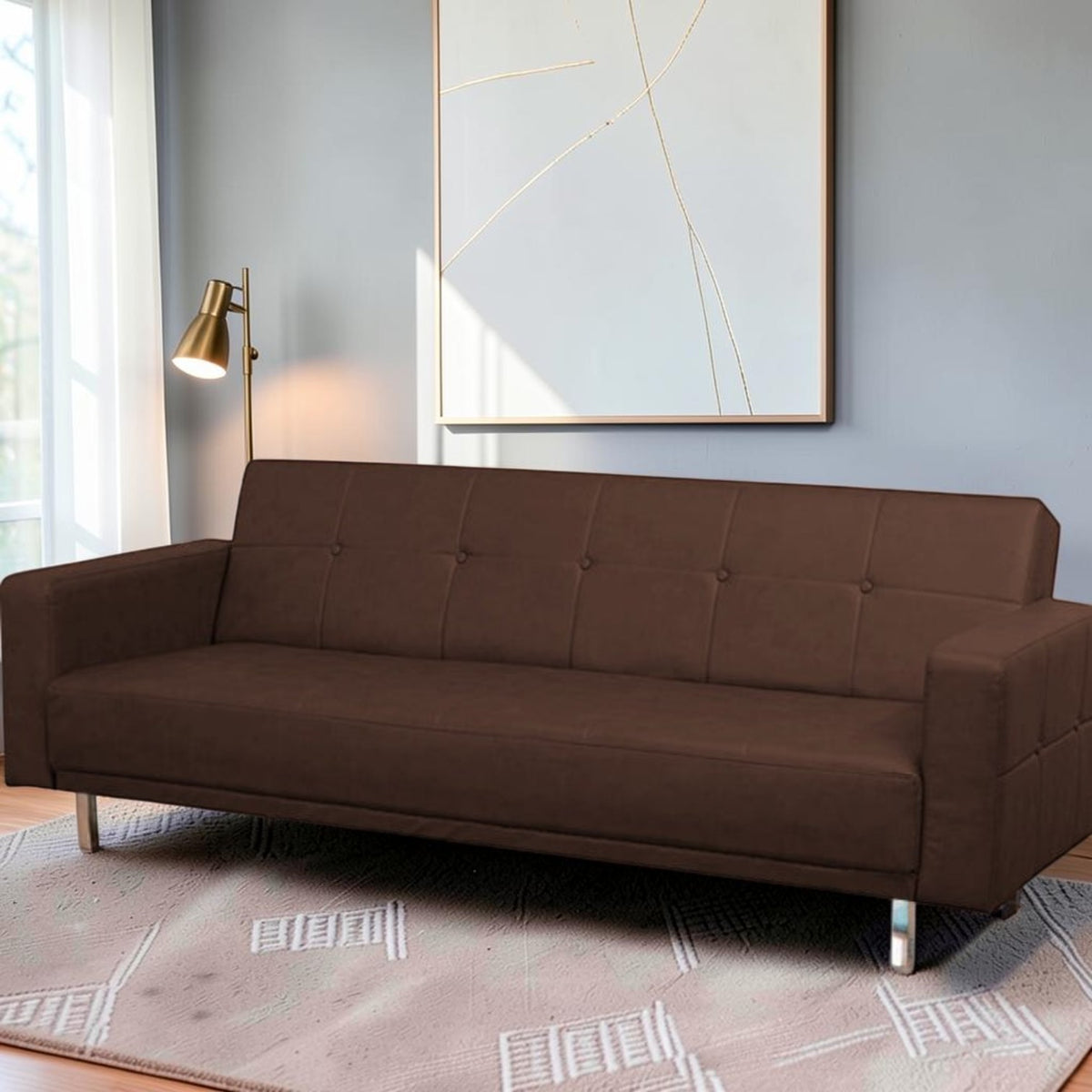 Homecrest Corbett brown leatherette three-seater sofa bed with tufted backrest and modern metal legs in a living room.