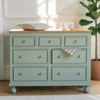 Homecrest Corin wide lowboy chest in sage green with solid mango wood top, framed drawers, and turned wooden knobs.