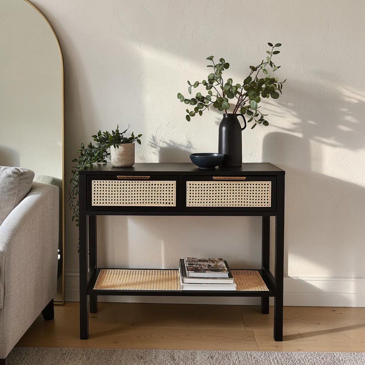 Homecrest Corvin black mango wood console table with two rattan cane doors and a lower storage shelf in a living room