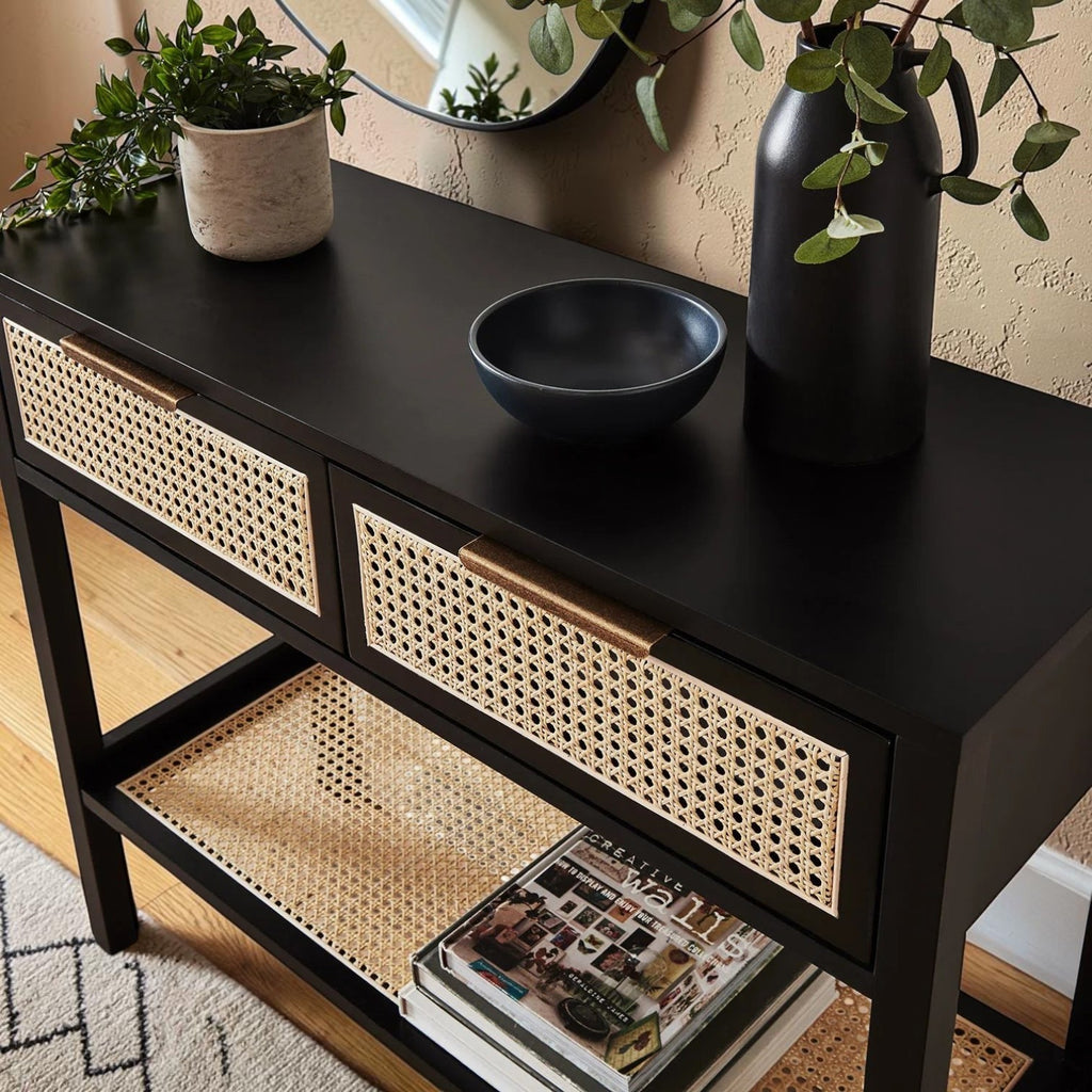 Homecrest Corvin black mango wood console table with two rattan cane doors and a lower shelf in a modern hallway