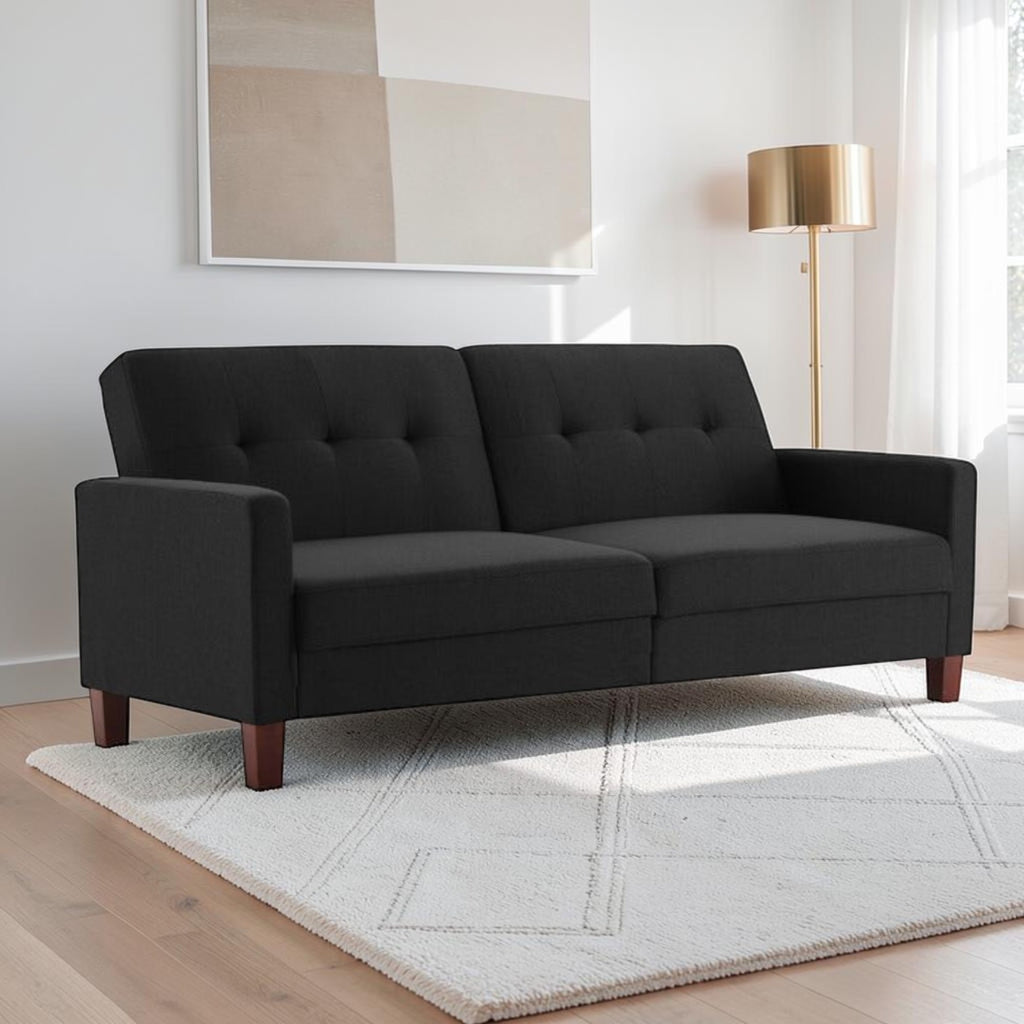 Homecrest Delaney black three-seater sofa bed with tufted back cushions and solid wood legs in a modern living room.