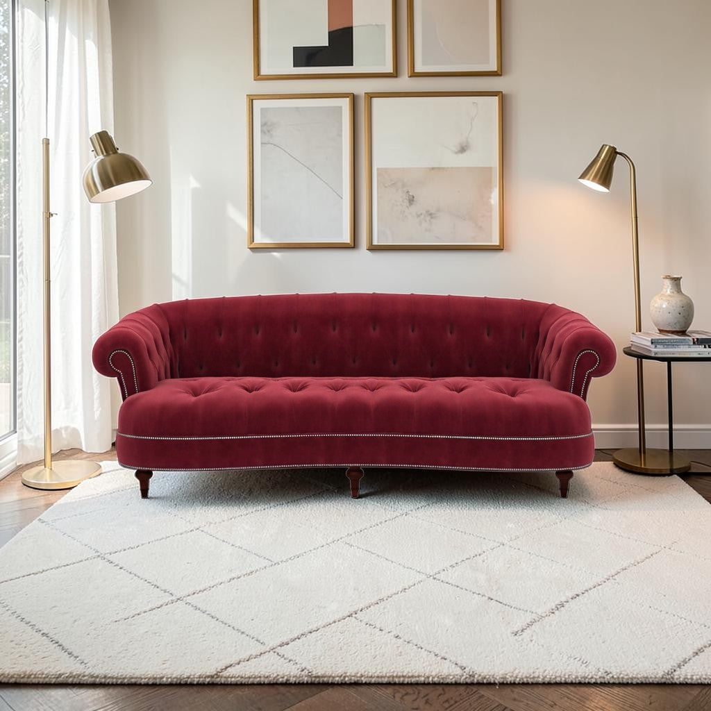 Homecrest Dunmore Chesterfield sofa in pomegranate velvet with tufted back and silver nailhead trim in a living room.