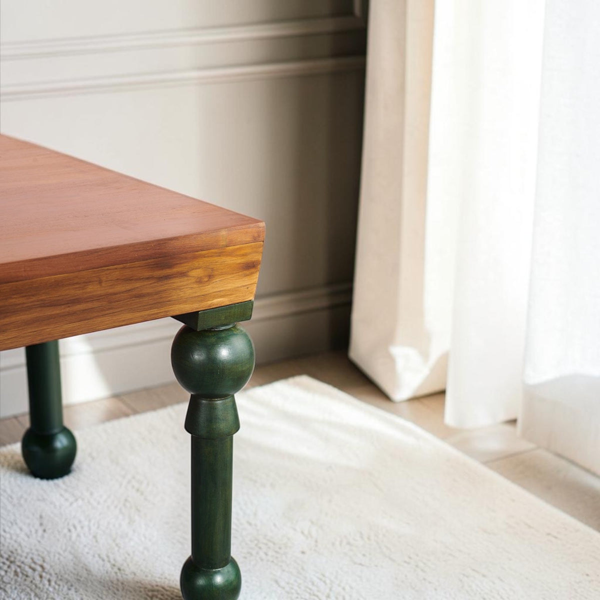 Homecrest Ellis teak dining table with a natural wood top and distinctive teal painted turned legs on a rug