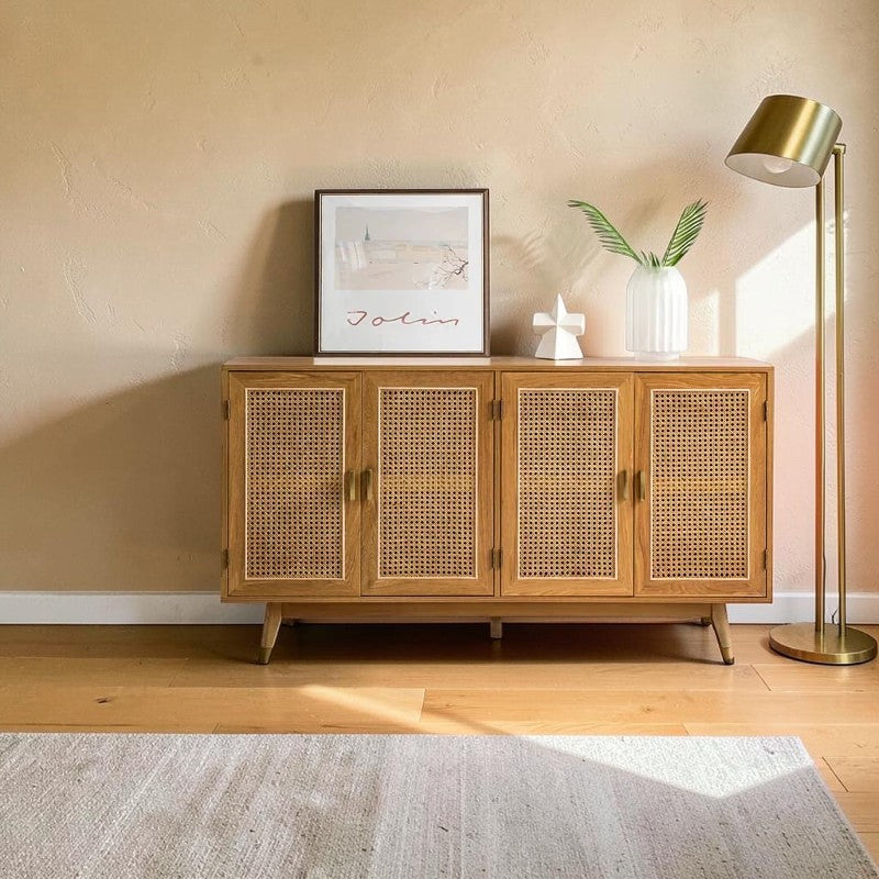 Homecrest Emsley four-door sideboard in natural acacia wood with cane front panels, styled in a warm living room.