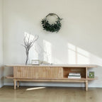 Homecrest Fallow media cabinet in natural mango wood with a fluted sliding door and open shelving in a bright room.