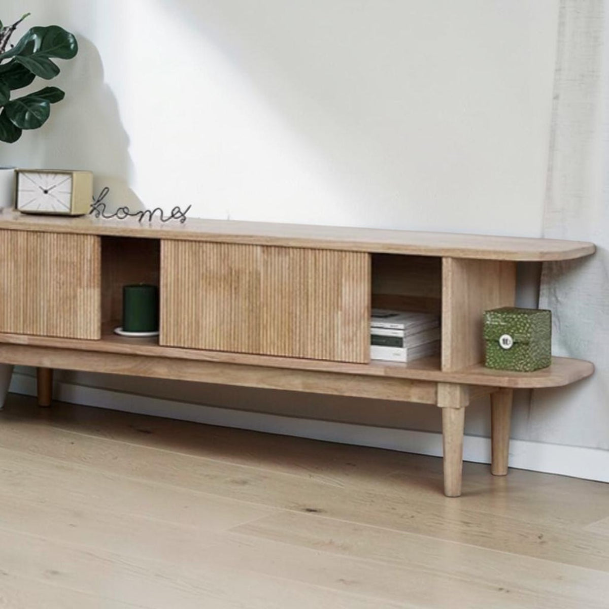 Homecrest Fallow media cabinet in natural mango wood with a fluted sliding door and open shelving.