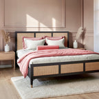 Homecrest Keston black solid mango wood bed frame with natural rattan cane headboard and footboard in a bedroom.