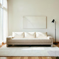 Homecrest Framlingham three-seater sofa in white cotton linen fabric against a rustic wall with a vintage rug
