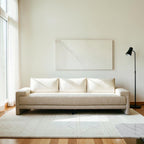 Homecrest Framlingham three-seater sofa in white cotton linen fabric against a rustic wall with a vintage rug