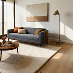 Homecrest 3-seater sofa in grey fabric with a tufted back and solid wood frame in a modern living room setting.