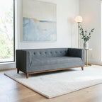 Homecrest 3-seater sofa in grey fabric with a tufted back, box arms, and a natural solid wood frame in a living room.