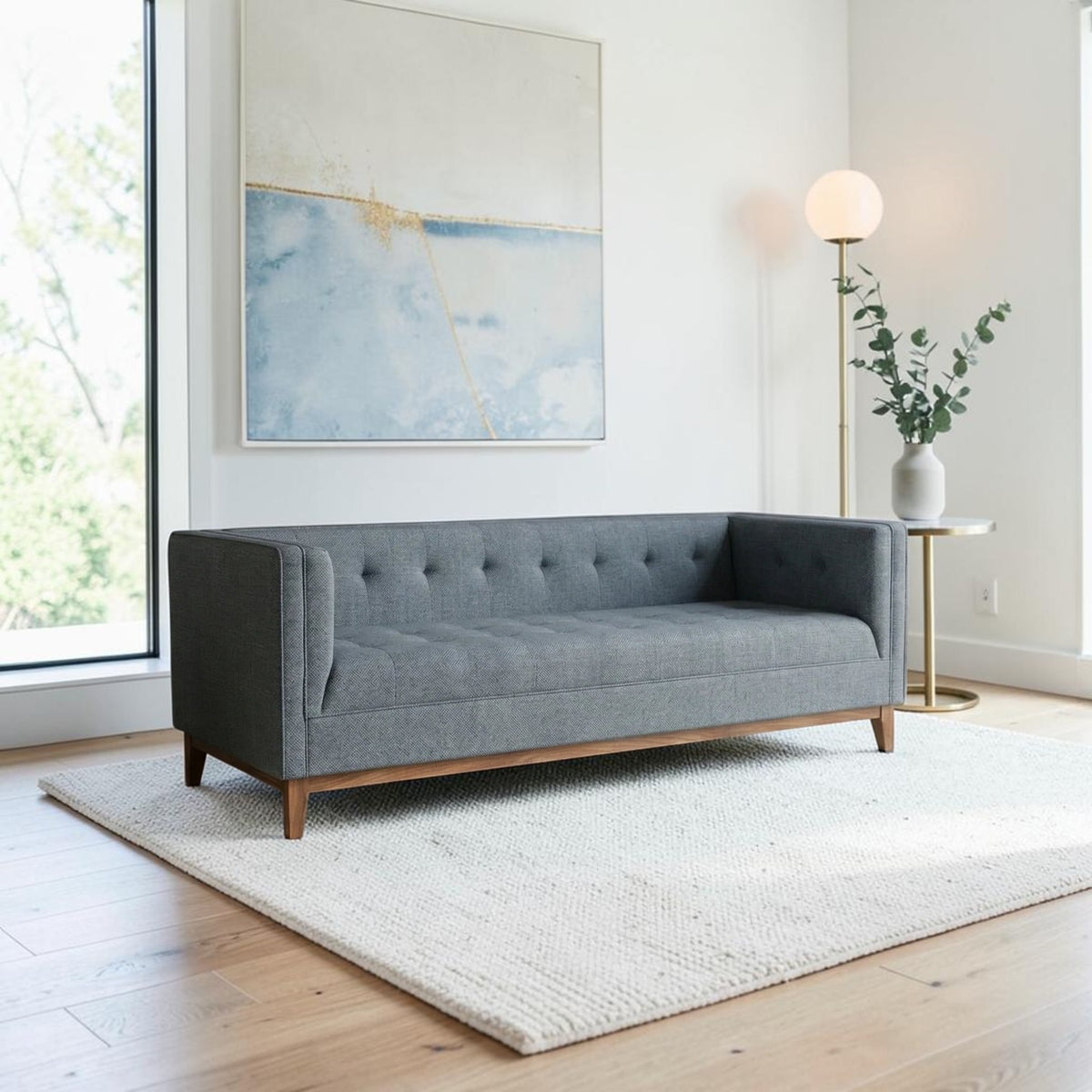 Homecrest 3-seater sofa in grey fabric with a tufted back, box arms, and a natural solid wood frame in a living room.