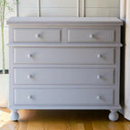Homecrest grey solid mango wood five-drawer chest with beaded moulding and classic bun-foot legs.