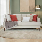 Homecrest Halden mid-century modern beige sofa with red and white accent pillows and a throw blanket in a living room