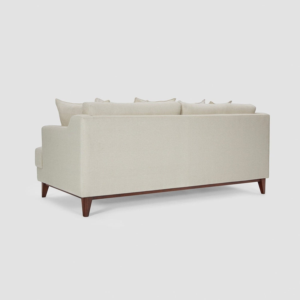 Homecrest Halden mid-century lounge sofa in beige fabric with a dark teak wood base and tapered legs, rear view.
