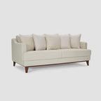 Homecrest Halden mid-century modern sofa in cream fabric with tapered teak wood legs in a minimalist living room.
