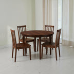 Homecrest Halland round dining table in dark wood with four matching spindle-back chairs in a bright dining room.