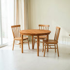 Homecrest Halland round sheesham wood dining table with three matching spindle-back chairs in a bright room