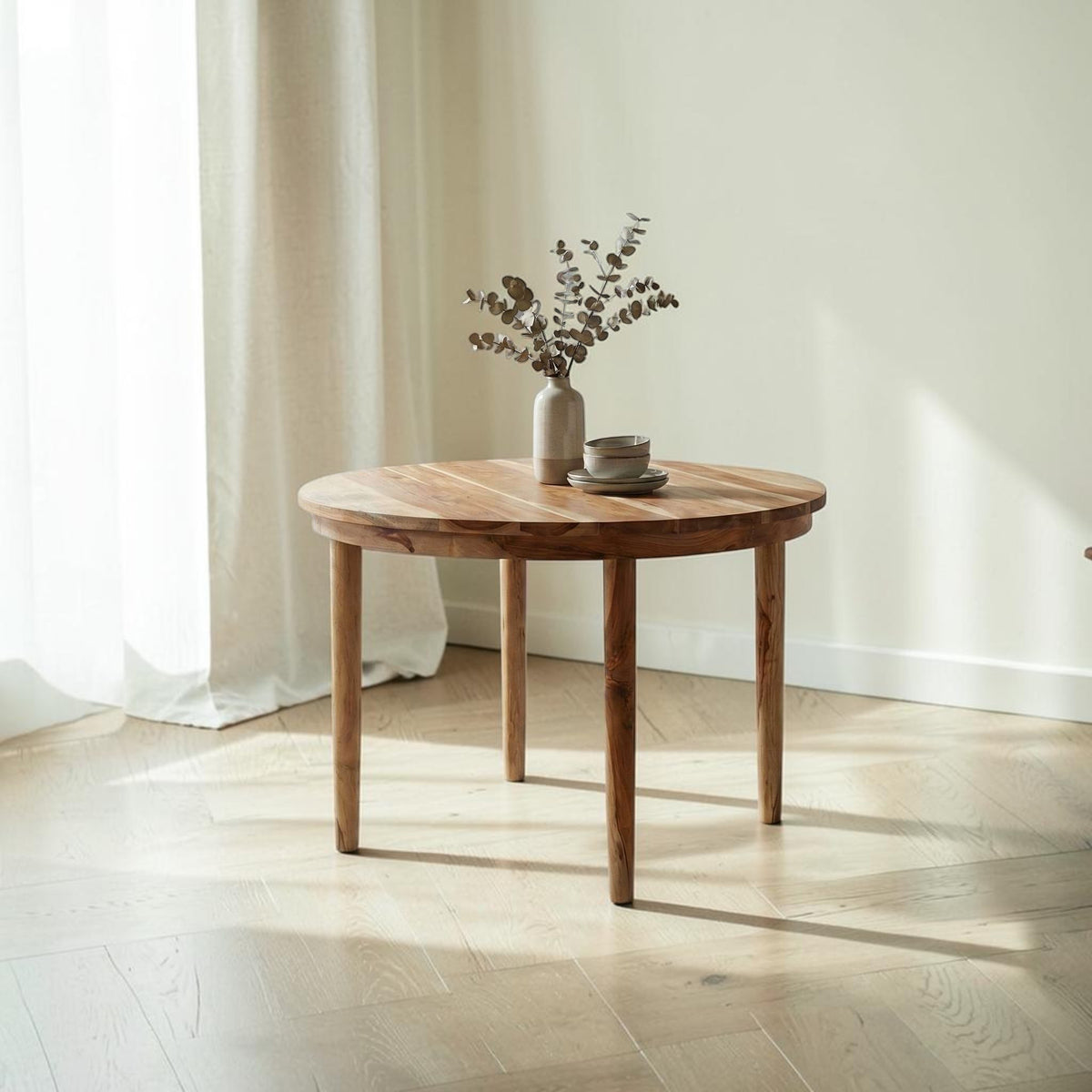 Homecrest Halland round dining table in sheesham wood with a minimal Scandinavian design in a bright living space