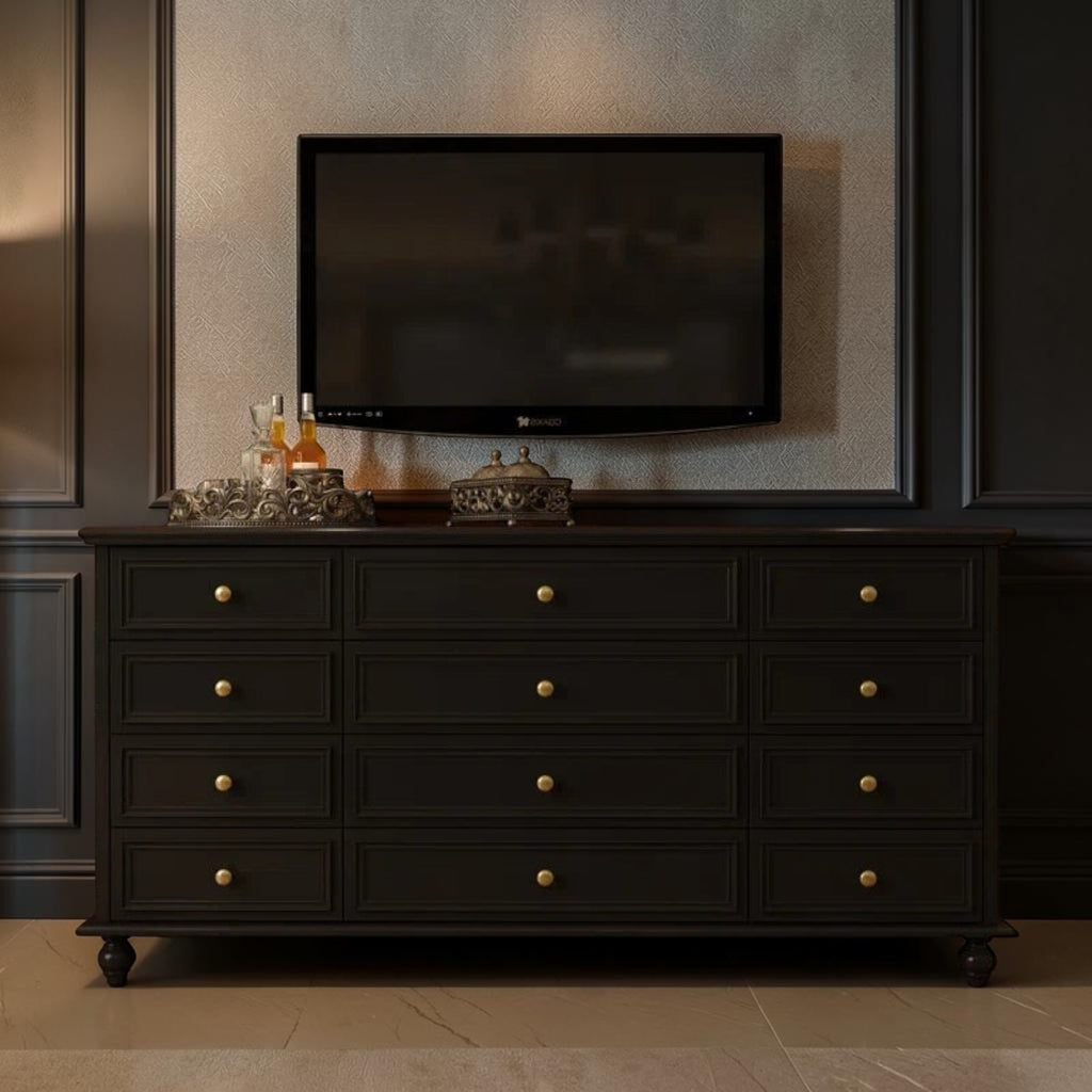 Homecrest Halstead twelve-drawer chest in black sheesham wood with brass knobs, positioned under a wall-mounted TV.