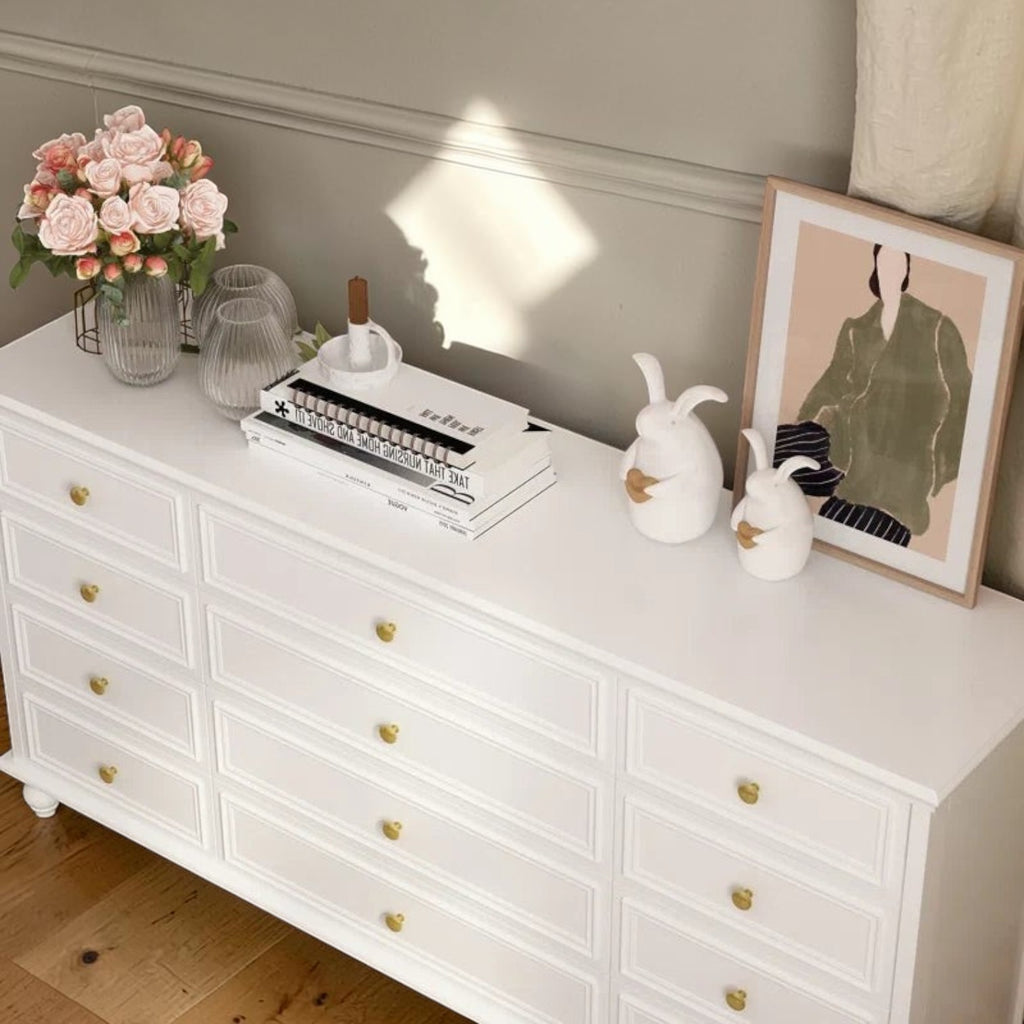 Homecrest Halstead white twelve-drawer chest made of sheesham wood with gold knobs, styled with decor on top.