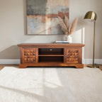 Homecrest Idris low-rise media unit in solid sheesham wood with geometric cabinet doors and a natural matte finish.