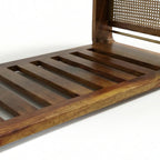 Homecrest Ilva coffee table featuring a slatted Sheesham wood base and a decorative rattan cane panel side detail.