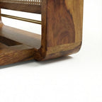 Homecrest Ilva coffee table featuring a curved Sheesham wood frame and intricate rattan cane panel detailing.