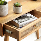 Homecrest Isla console table in natural wood with a woven rattan cane drawer front and gold handle, open drawer view.