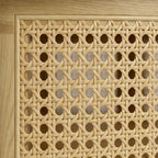 Close-up of the Homecrest Juno coffee table featuring intricate natural woven cane paneling framed in light solid wood.