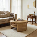 Homecrest Juno round coffee table in light natural wood with woven cane side panels and a lower storage shelf.