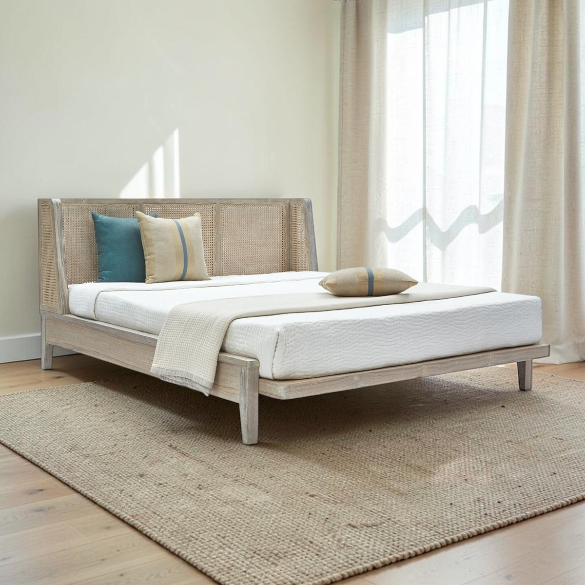 Homecrest Kelsale teakwood bed featuring a winged natural wicker headboard and a white Belgian Monocoat finish.