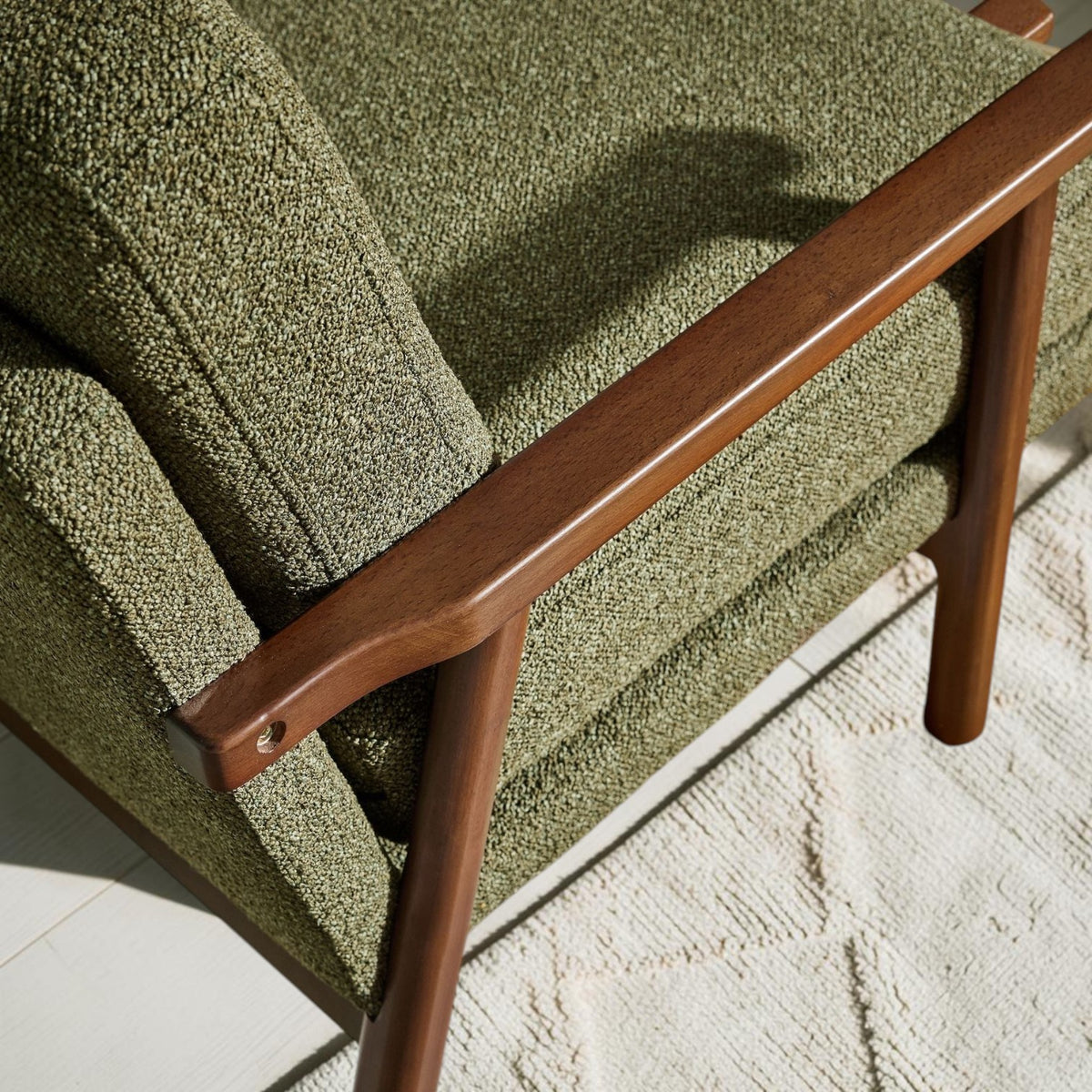Homecrest Lars Scandi accent chair featuring a dark solid wood frame and textured olive green bouclé upholstery.