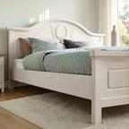 Homecrest luxury standard bed in light beige PU finish with a carved wreath detail on the arched wooden headboard.