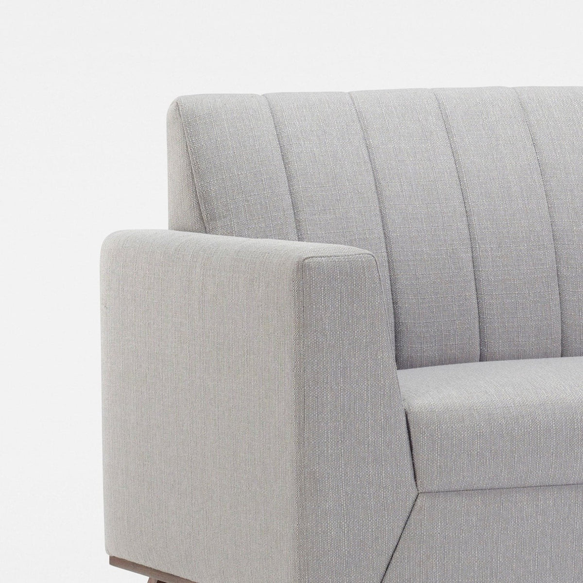Homecrest Lindholm Scandinavian statement sofa in light grey fabric with a channel-tufted back and teak wood base.