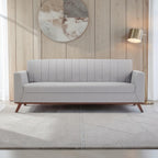 Homecrest Lindholm Scandinavian statement sofa in light grey fabric with a teak wood base in a modern living room.