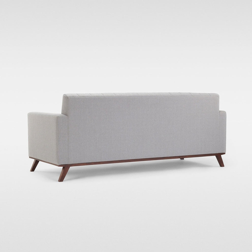 Homecrest Lindholm Scandinavian statement sofa in light grey fabric with a teak wood base viewed from the back