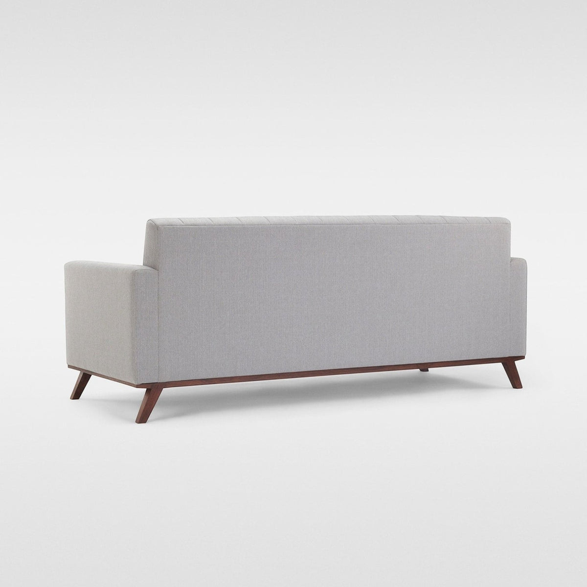 Homecrest Lindholm Scandinavian statement sofa in light grey fabric with a teak wood base viewed from the back