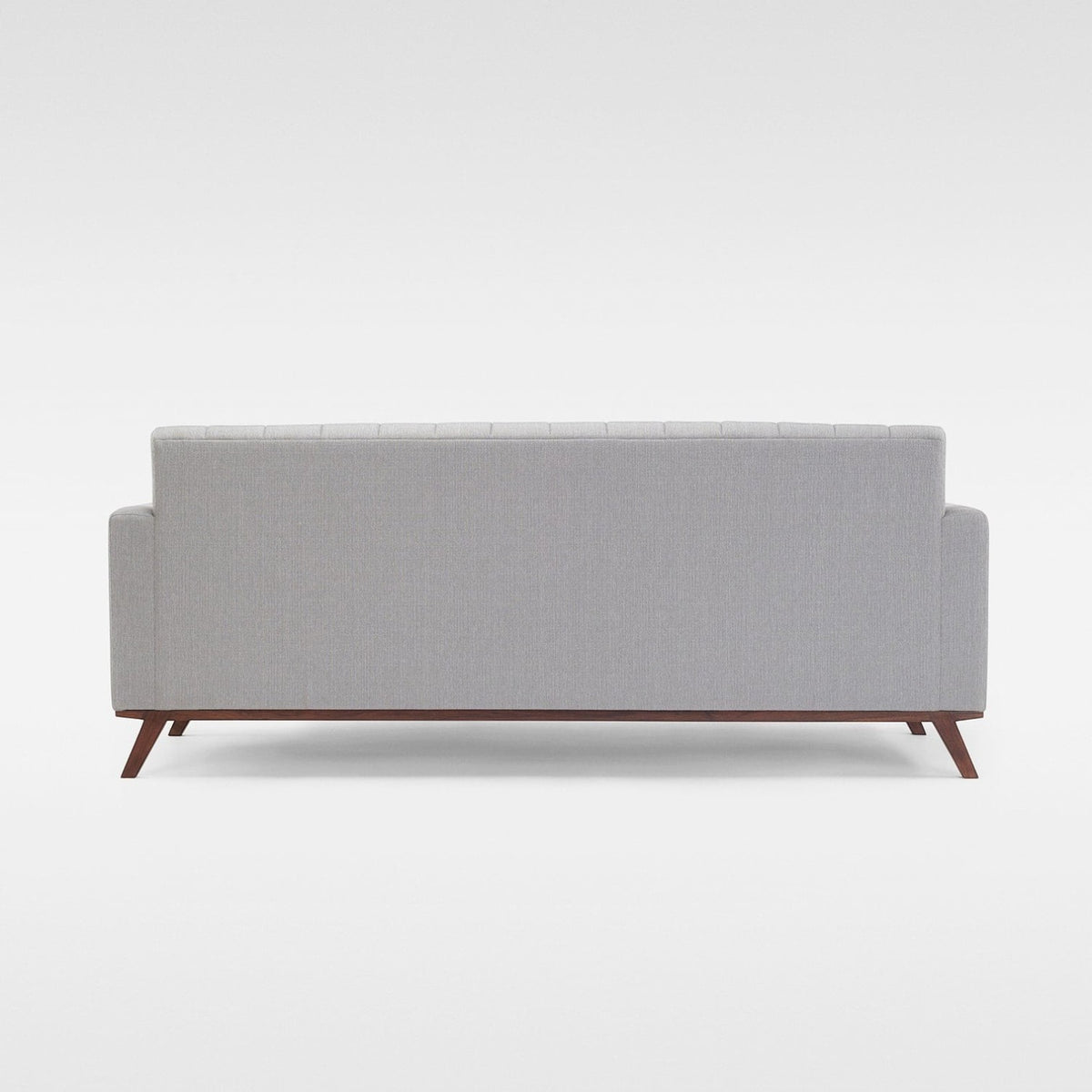 Homecrest Lindholm Scandinavian statement sofa in light grey fabric with a teak wood base, back view.