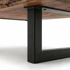Homecrest Kestrel coffee table featuring a natural live edge solid wood slab and a black powder-coated metal base.
