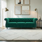 Homecrest Berkley 3-seater Chesterfield sofa in emerald green velvet with tufted back and nailhead trim in a living room.