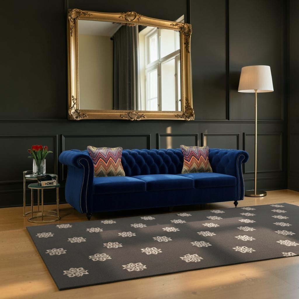 Homecrest Berkley three-seater Chesterfield sofa in indigo blue velvet with tufted back and patterned accent cushions.