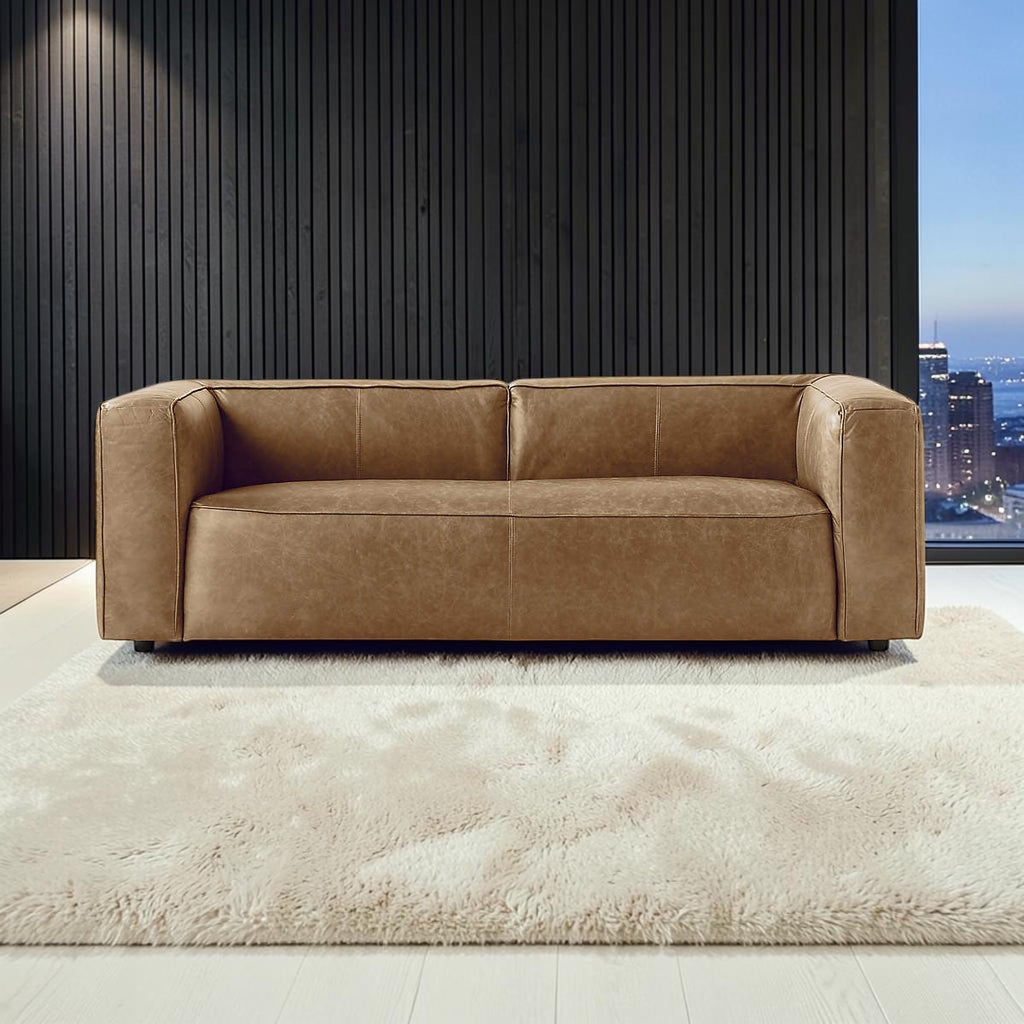 Homecrest Manhattan three-seater sofa in saddle-toned upholstery on a plush cream rug in a modern living room.