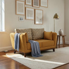 Homecrest 2-seater sofa in mustard fabric with patterned back cushions, curved armrests, and a light blue throw blanket.
